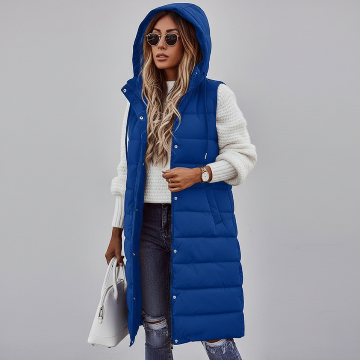 female model in blue long puffer vest with hood styled with denim winter outfit