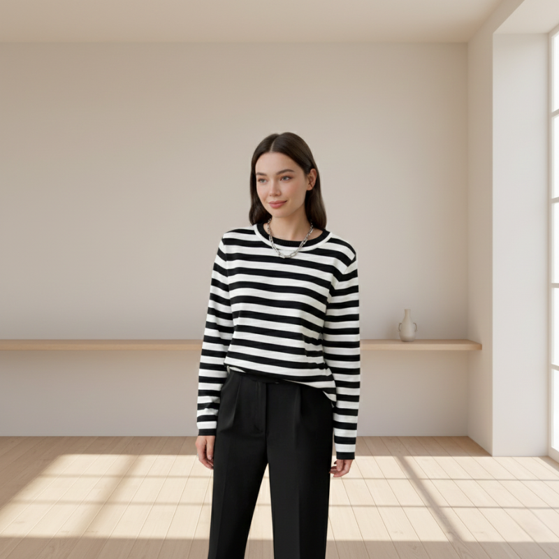 full-body indoor shot of model wearing striped sweater and black pants in bright room